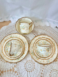 Set of decorative plates and a teacup on a lace tablecloth