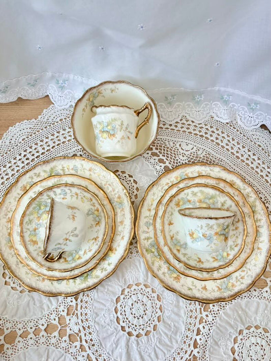 Set of decorative plates and a teacup on a lace tablecloth