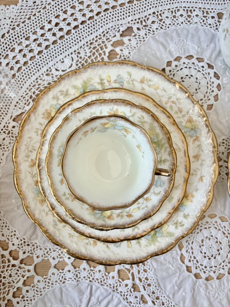 Stack of ceramic plates with gold trim on a lace tablecloth