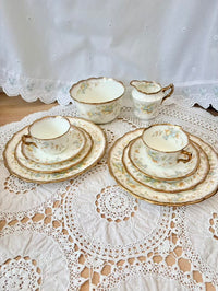 Vintage tea set with floral patterns on a lace tablecloth