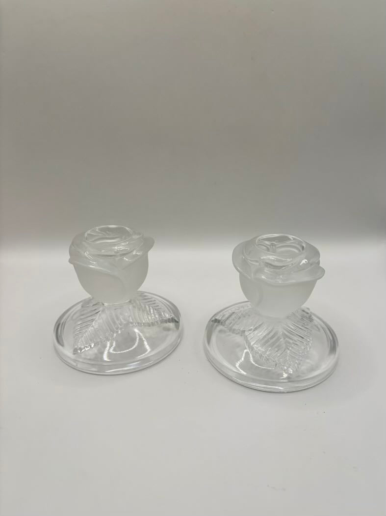 Two clear glass candle holders on a white background