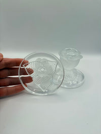 Clear glass lid held by a hand on a white background