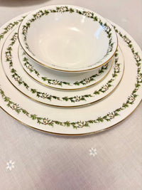 Set of ceramic plates with green floral pattern on a light gray background