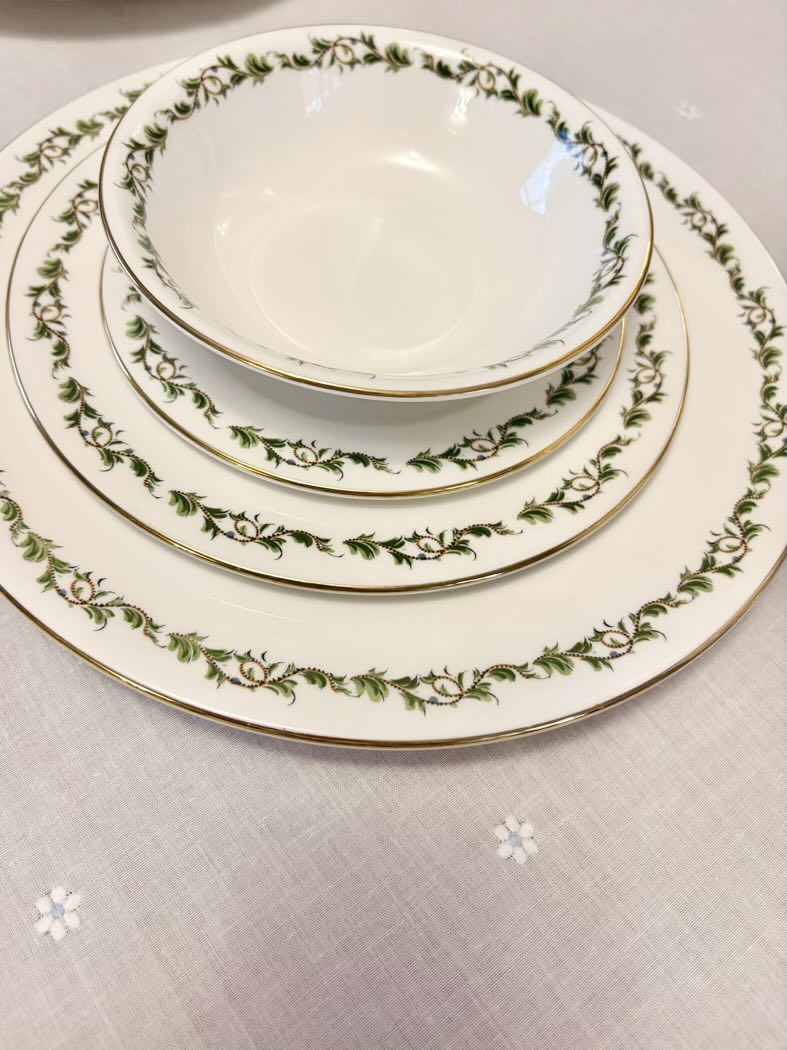 Set of ceramic plates with green floral pattern on a light gray background