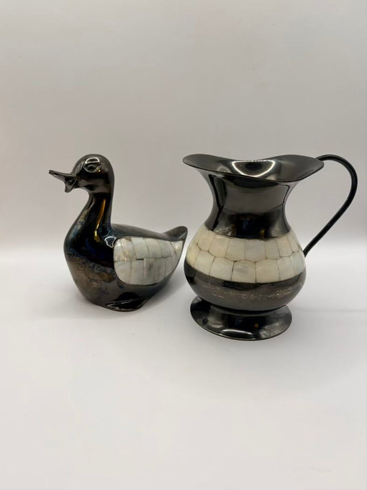 Black and white ceramic duck and pitcher on a light gray background