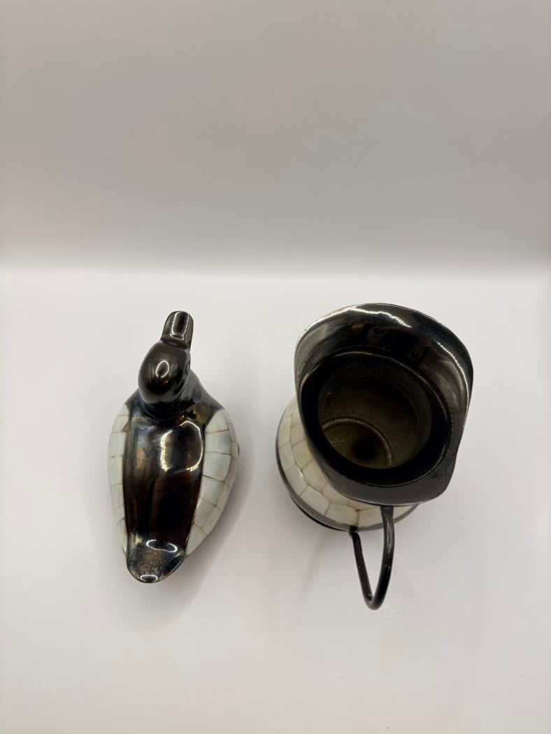 Black ceramic teapot with a horse head spout on a white background