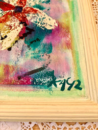 Colorful abstract painting with a signature in a wooden frame.