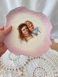Decorative plate with an illustration of two children on a lace doily