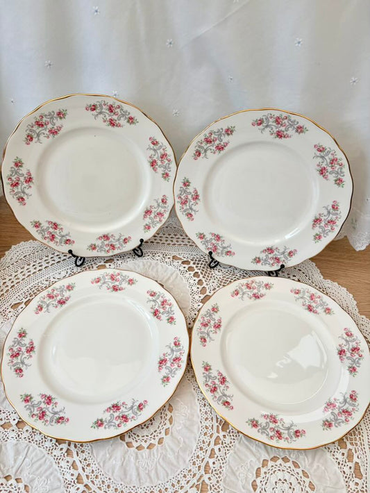 Four floral-patterned plates on a lace tablecloth