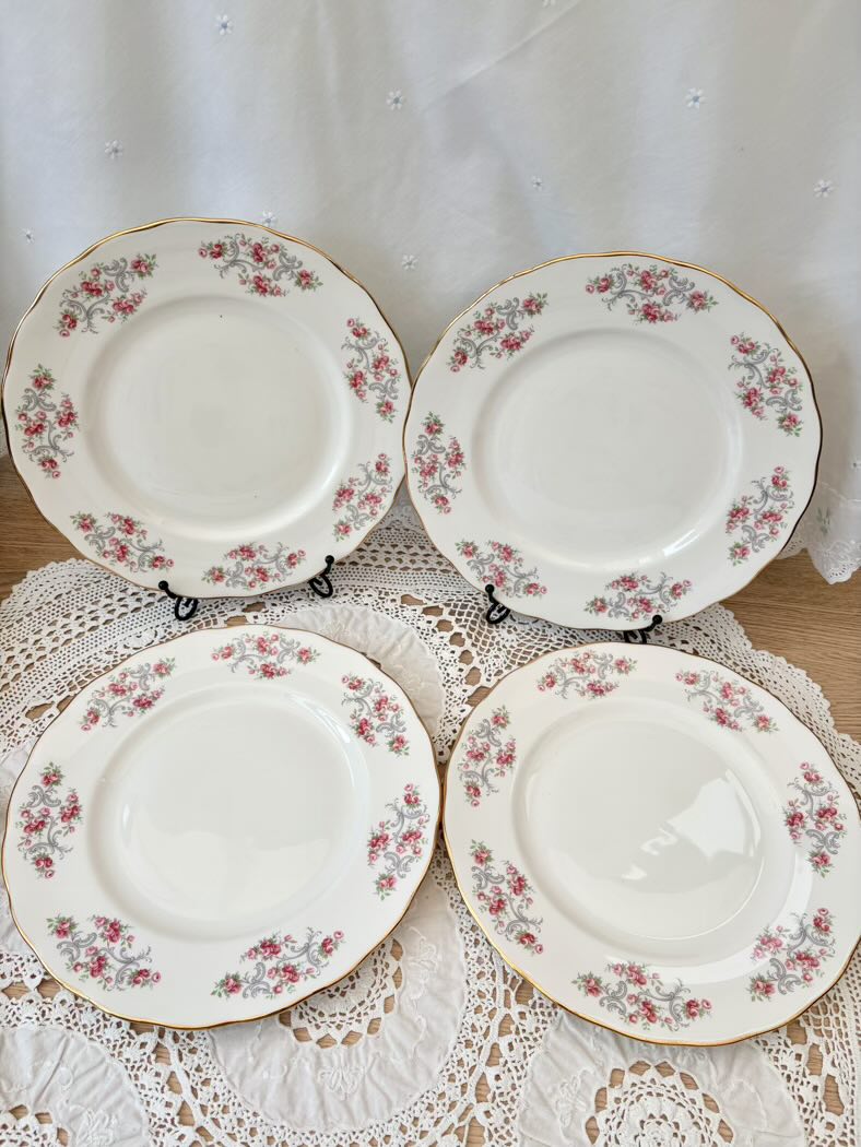 Four floral-patterned plates on a lace tablecloth