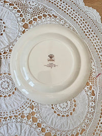 White ceramic plate with a logo on a lace tablecloth