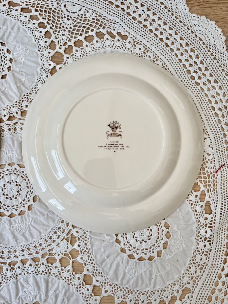 White ceramic plate with a logo on a lace tablecloth