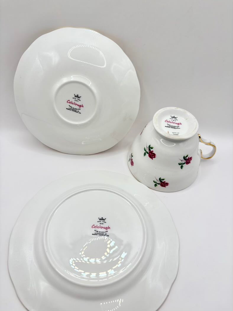Set of white teacup and saucers with floral design on a gray background