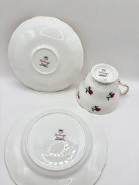 Set of white teacup and saucers with floral design on a gray background