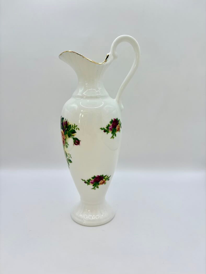 White ceramic pitcher with floral patterns on a white background