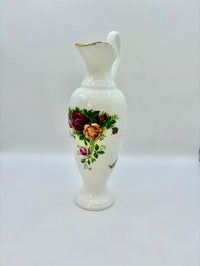 White ceramic pitcher with floral design on a white background
