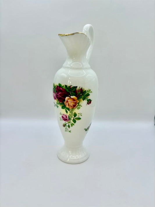 White ceramic pitcher with floral design on a white background