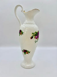 White ceramic pitcher with floral designs on a white background