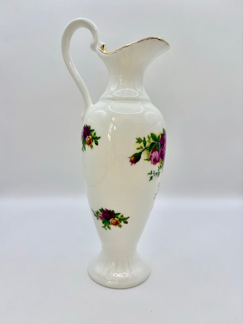 White ceramic pitcher with floral designs on a white background