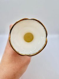 Hand holding a vase against a plain background