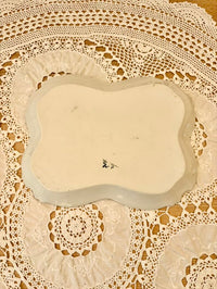 Rectangular ceramic plate with decorative edge on a lace tablecloth