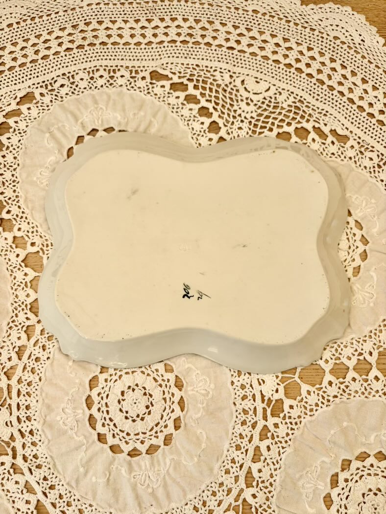 Rectangular ceramic plate with decorative edge on a lace tablecloth