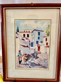 Framed artwork of a village scene with a man and donkey.