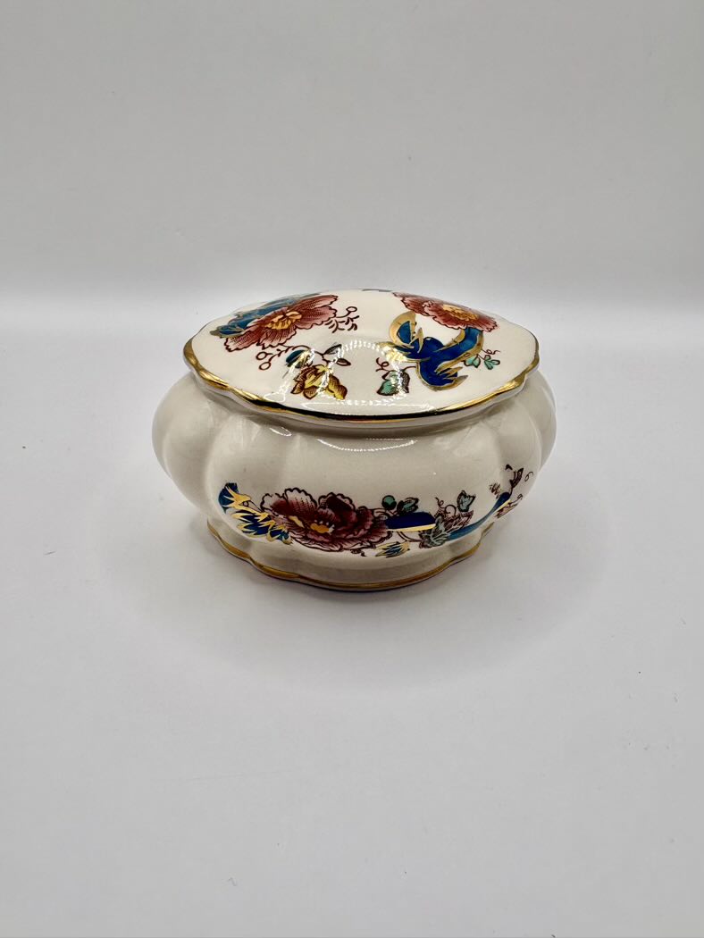 Decorative ceramic trinket box with floral patterns on a white background