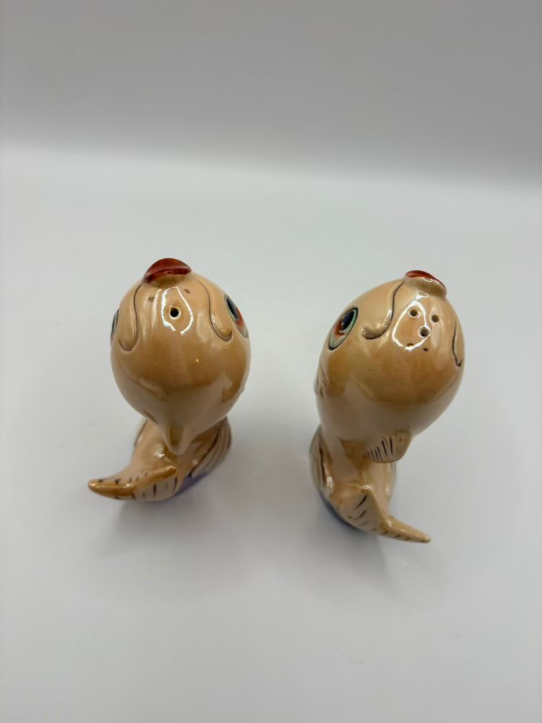 Two ceramic shaker figurines on a white background