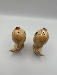 Two ceramic shaker figurines on a white background