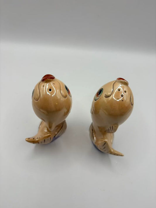 Two ceramic shaker figurines on a white background