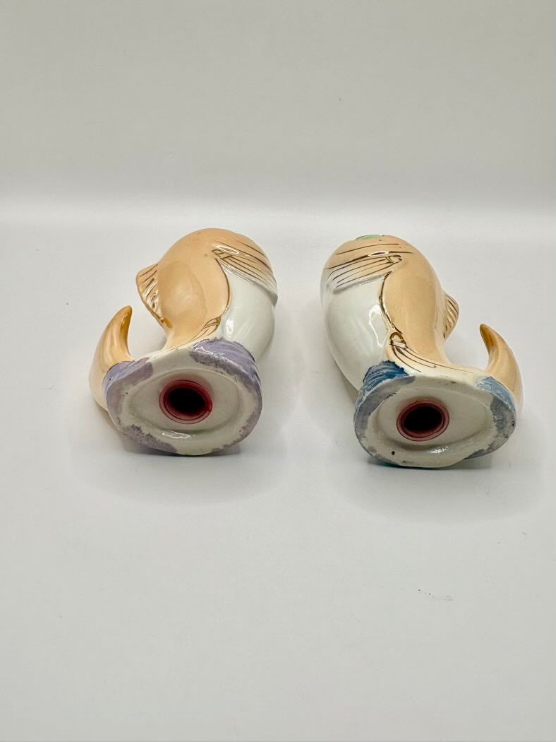 Two ceramic shakers with decorative patterns on a white background