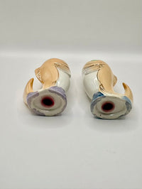 Two ceramic shakers with decorative patterns on a white background