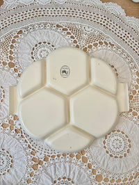White ceramic plate with hexagonal sections on a lace tablecloth