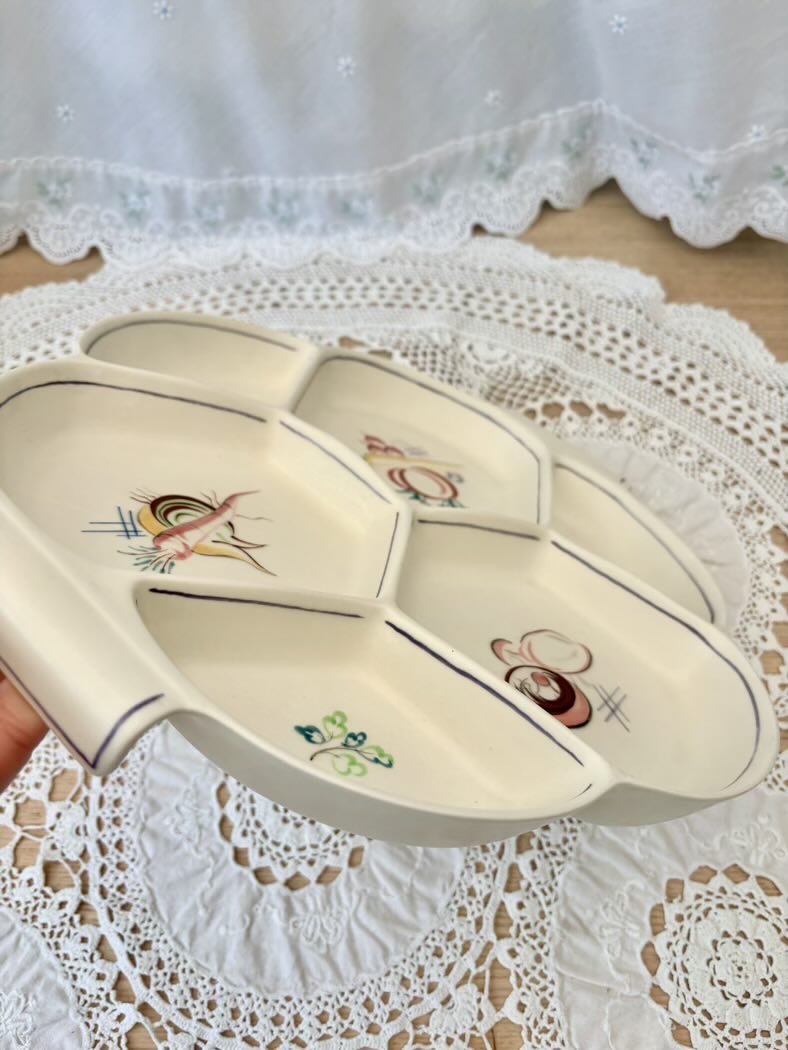 Decorative fruit bowl with cartoon designs on a lace tablecloth