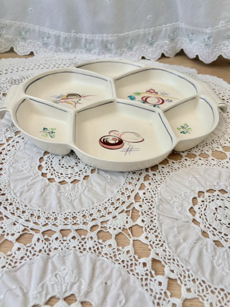 Decorative ceramic plate with floral designs on a lace tablecloth