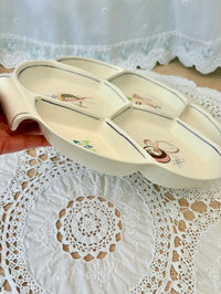 Decorative ceramic dish with cartoon characters on a lace tablecloth