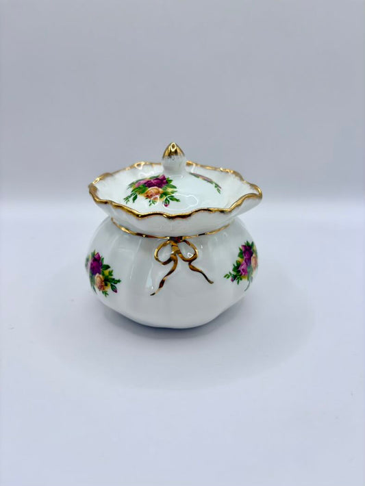 Decorative ceramic lidded container with floral designs on a white background