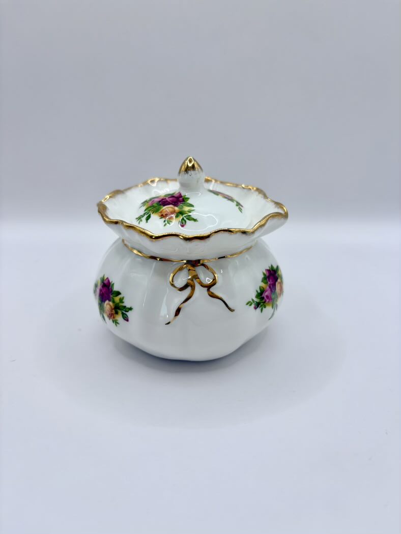 Decorative ceramic lidded container with floral designs on a white background