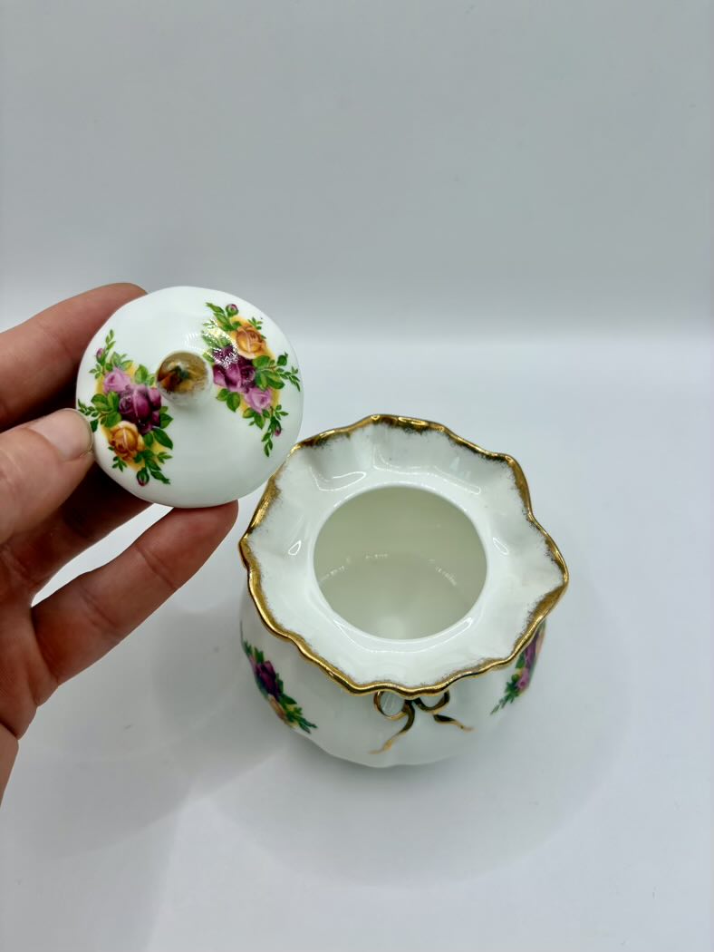 Decorative ceramic container with floral designs on a white background