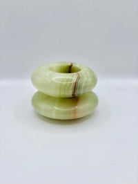 Stack of green stone rings on a white background