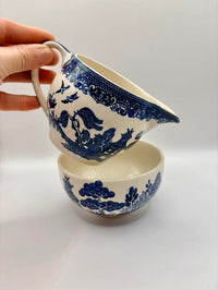 Ceramic bowl and pitcher set with blue floral patterns on a white background