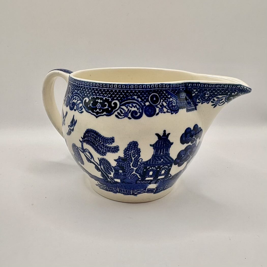 Blue and white ceramic pitcher on a light gray background