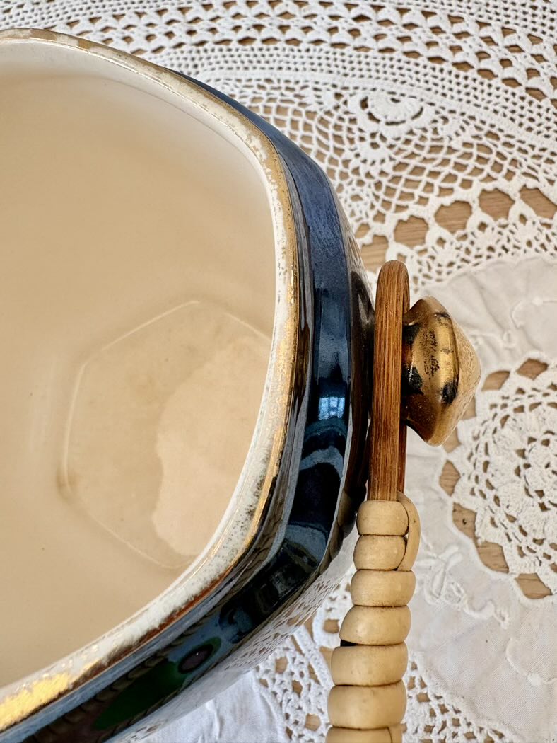 Ceramic pot with wooden handle on a lace tablecloth