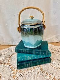 Ceramic jar with a handle on top of stacked books on a lace surface