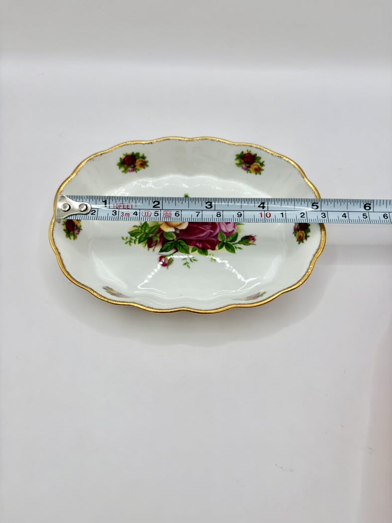 Decorative plate with floral design and gold rim, measured against a white background