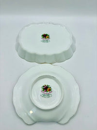 Two white ceramic plates with floral designs on a gray background