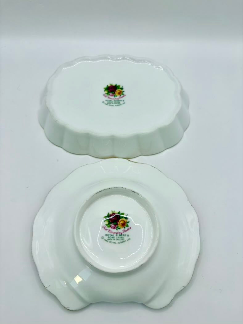 Two white ceramic plates with floral designs on a gray background