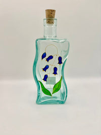Decorative glass bottle with blue floral design on a white background