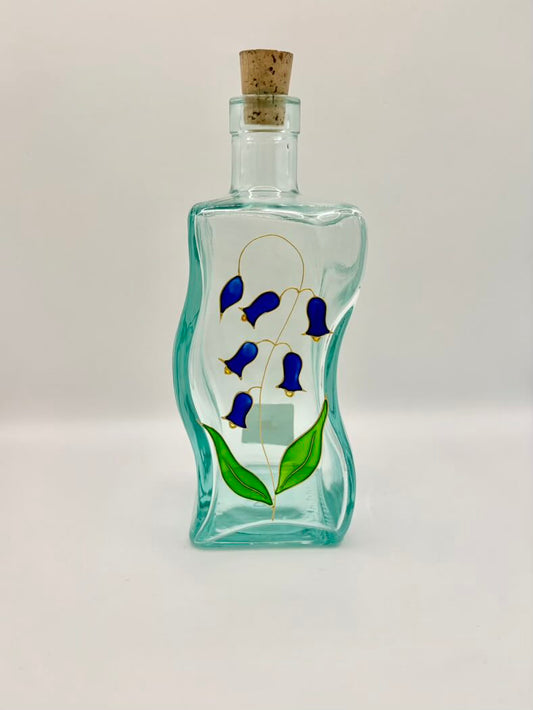 Decorative glass bottle with blue floral design on a white background